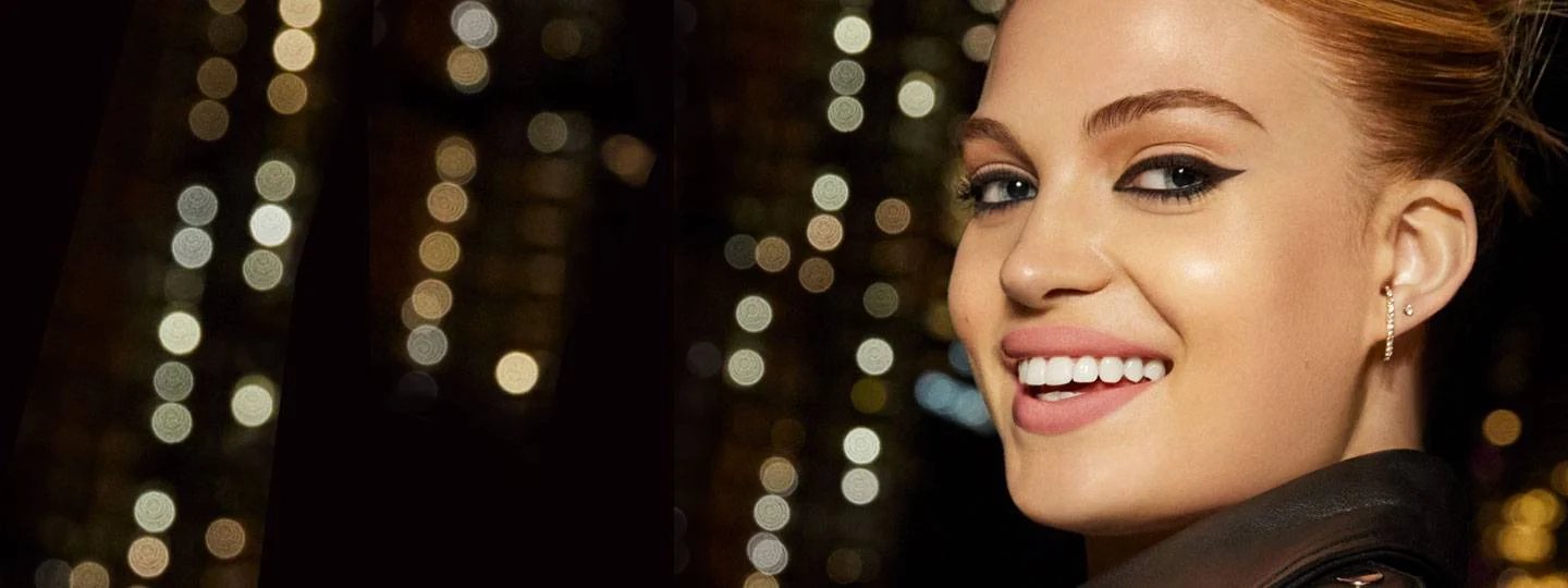 Kvinde smiler – byens lys i baggrunden